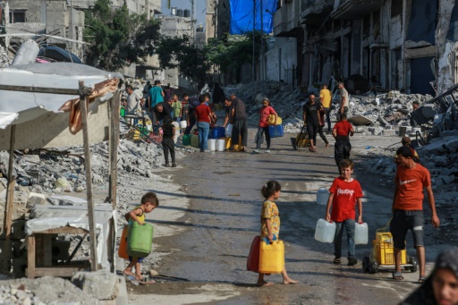 Des Palestiniens dans une file d'attente pour remplir des bidons d'eau à Khan Younès, dans le sud de la bande de Gaza, le 14 juillet 2024
