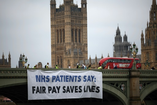 Une banderole sur le pont de Westminster pour soutenir la grève des jeunes médecins qui réclament de meilleurs salaires et conditions de travail, le 27 juin 2024 à Londres
