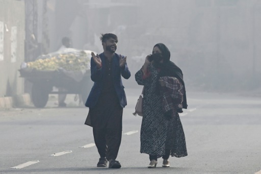 Des promeneurs affrontent le smog dans les rues de Lahore le 2 novembre 2024.
