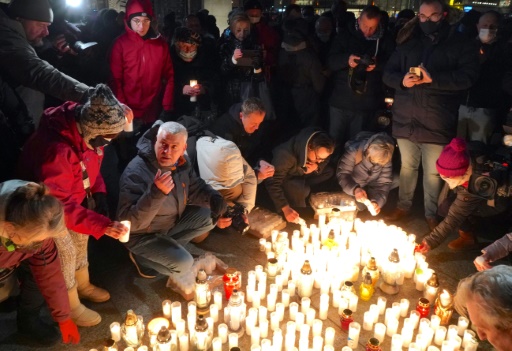 Des passants allument des bougies pour commémorer les décès dus au COVID-19, à Varsovie, le 11 janvier 2022

