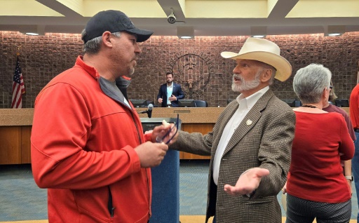 John Barrett (à droite) un habitant conservateur d'Amarillo, discute avec un autre habitant lors d'une session du conseil municipal de cette ville du Texas, le 28 mai 2024
