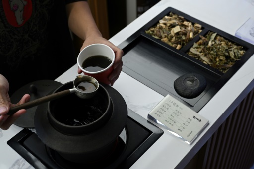 Un employé prépare une tisane dans un café du district de Xuhui, le 6 août 2024 à Shanghai 
