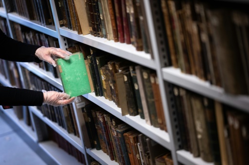 Aude Therstappen, conservatrice de la BNU (Bibliothèque nationale et universitaire) à Strasbourg, retire des réserves un livre coloré en vert avec l'arsenic, le 17 mai 2024
