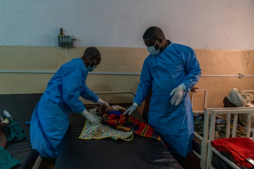 Le Dr Robert Musole (à droite), directeur médical de l'hôpital de Kavumu, en République démocratique du Congo examine un nourrisson atteint d'une forme grave de mpox le 24 août 2024
