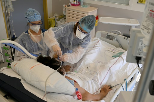 Des soignantes s'occupent d'un patient atteint du Covid-19 dans une unité de soins intensifs à l'hôpital de la Timone, à Marseille, le 5 janvier 2022
