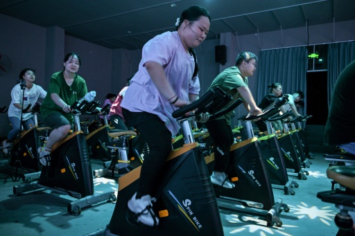 Cette photo prise le 23 octobre 2024 montre Yang Chi'ao (C) faisant de l'exercice dans un camp d'amaigrissement à Chengdu, dans la province chinoise du Sichuan (sud-ouest)
