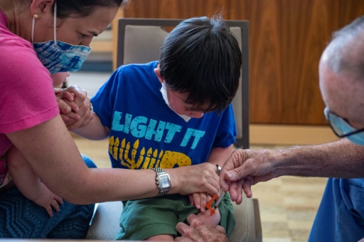 Un enfant de trois ans reçoit une dose de vaccin anti-Covid au Temple Beth Shalom à Needham, dans l'Etat du Massachusetts, le 21 juin 2022
