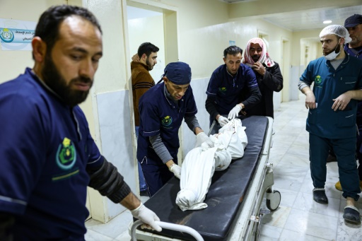 Le corps d'une victime de la guerre civile en Syrie transporté hors de l'hopital d'Idleb le 9 decembre 2023
