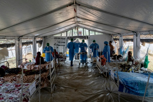 Des médecins et infirmières entrent dans une tente où sont hospitalisés des patients atteints du mpox à Kamituga, dans l'est de la RDC, le 20 septembre 2024
