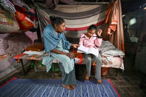 Harshita Gautam et sa mère Maya Devi, dans leur bidonville à New Delhi, en Inde, le 22 novembre 2024
