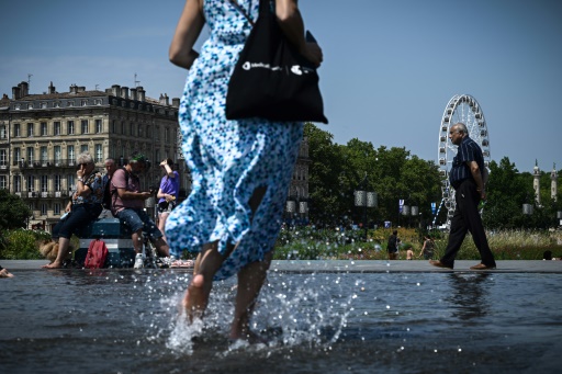 Une femme passe sur le Miroir d'eau, le 28 juillet 2024 à Toulouse
