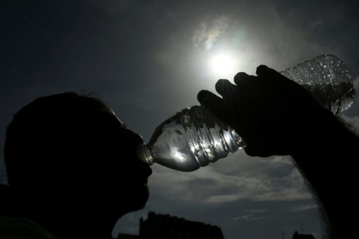 Une personne boit de l'eau d'une bouteille plastique le 25 juin 2019, à Mulhouse, dans le Haut-Rhin
