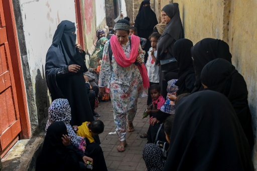 La sage-femme Neha Mankani (c) arrive à sa clinique devant laquelle des femmes enceintes attendent, le 11 juin 2024 sur l'île de Baba, au Pakistan
