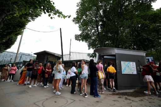 Des personnes font la queue devant les toilettes publiques dans une rue de Paris, en France, le 16 juillet 2024
